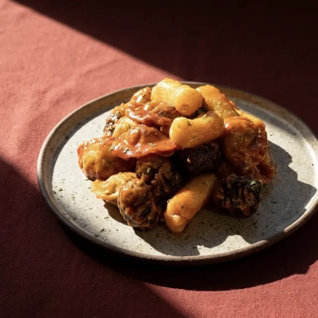 Fried rice cakes, seaweed rolls and dumplings in sweet chili sauce on a plate