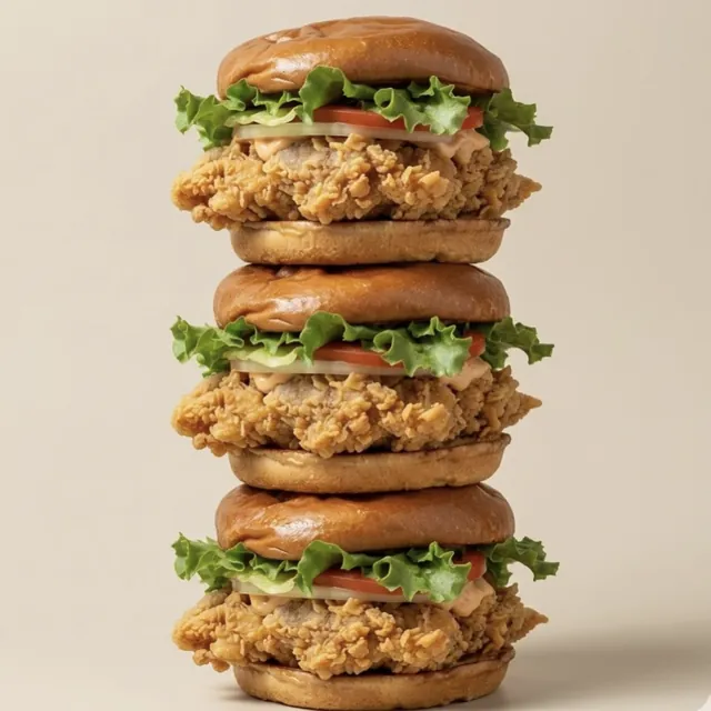 Three thigh burgers stacked on top of each other